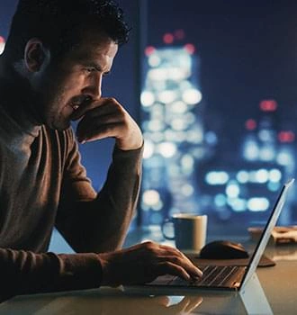 Man working late at a laptop, tired after a long, stressful day