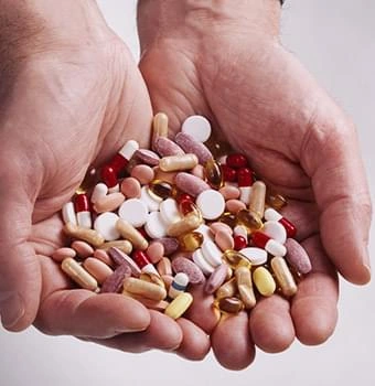 A handful of assorted pills, a reminder that food and habits come before supplements